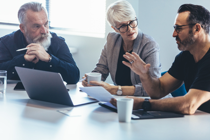 Three adults seated together reviewing shared property documents