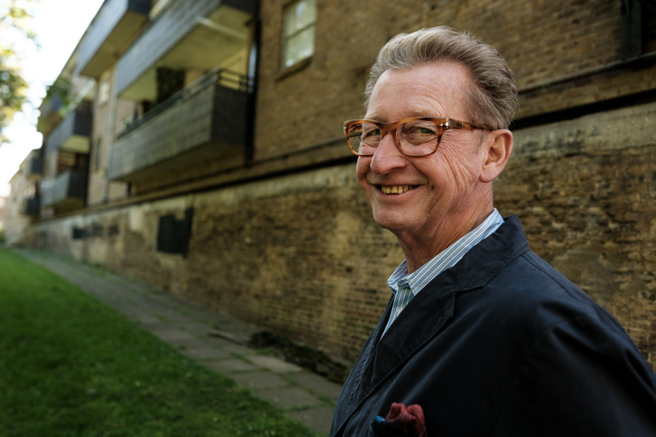 Long-time property owner outside a rental building he has managed directly.