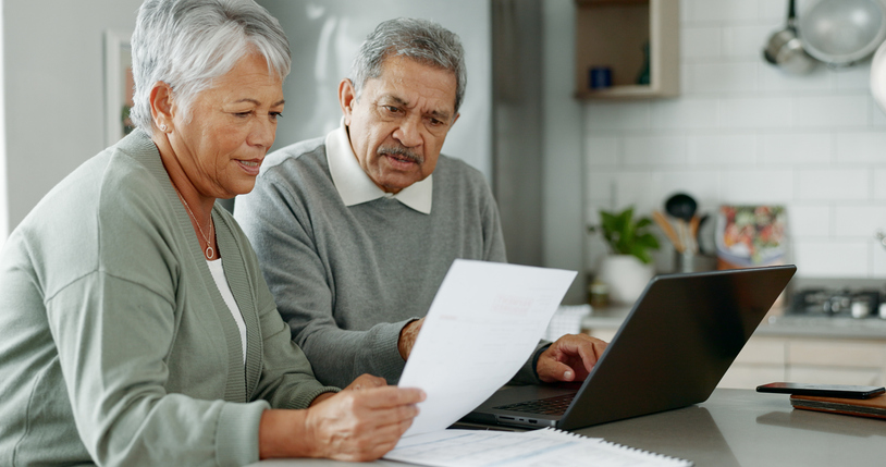 Experienced property owners reviewing exchange paperwork together at home.