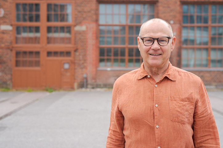 Older man standing outside a small commercial building