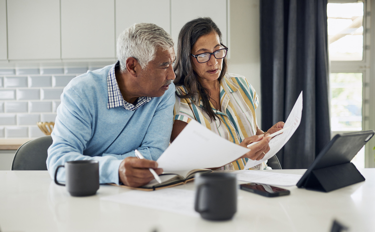 Couple looking over a calendar and paperwork at home