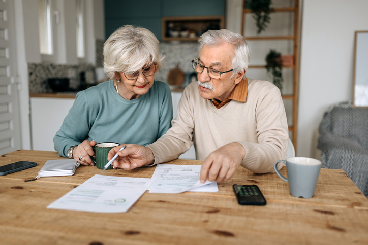 Retired couple at home reviewing paperwork together