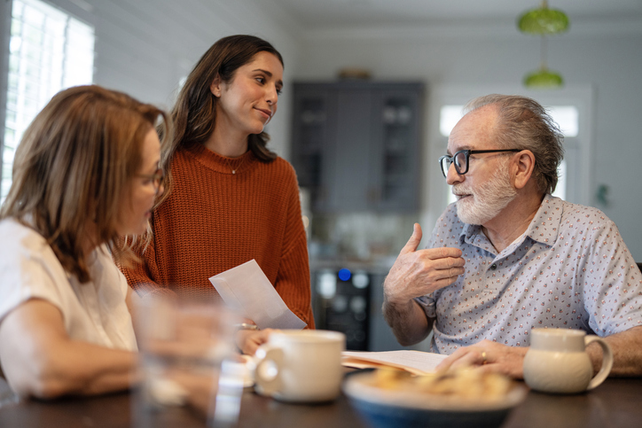 Older couple and their adult daughter reviewing documents