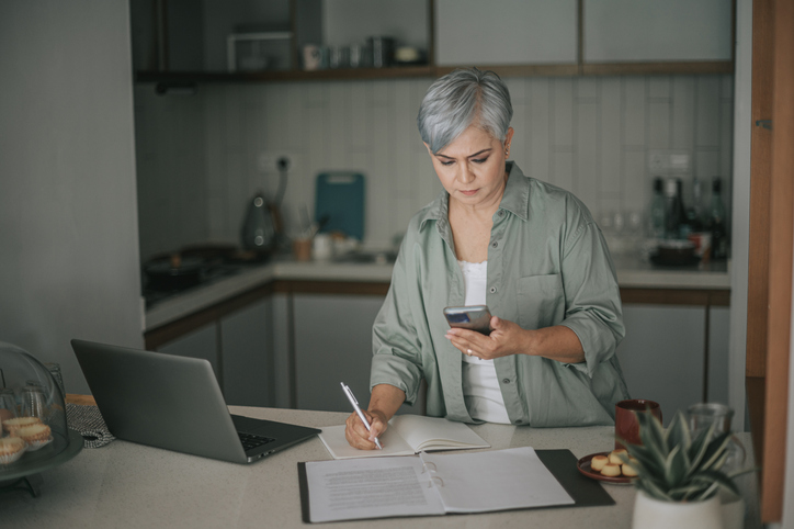 Woman in her seventies reading loan paperwork at a table